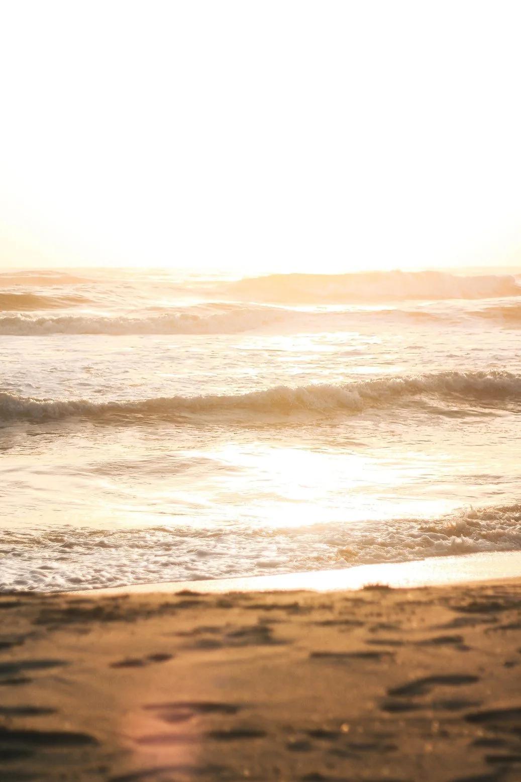 O mar ao entardecer sobre a areia