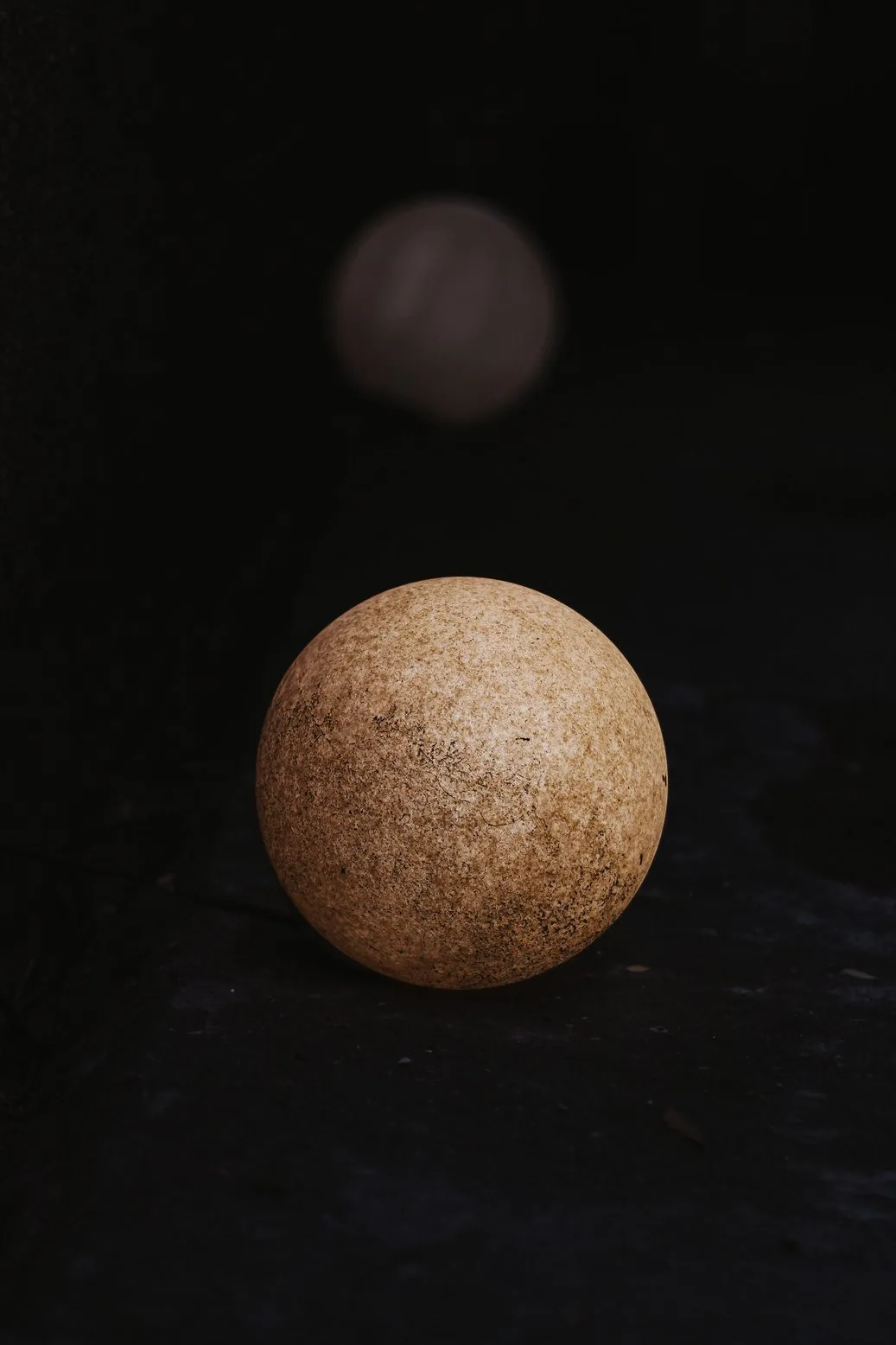 Uma esfera de pedra sobre fundo escuro