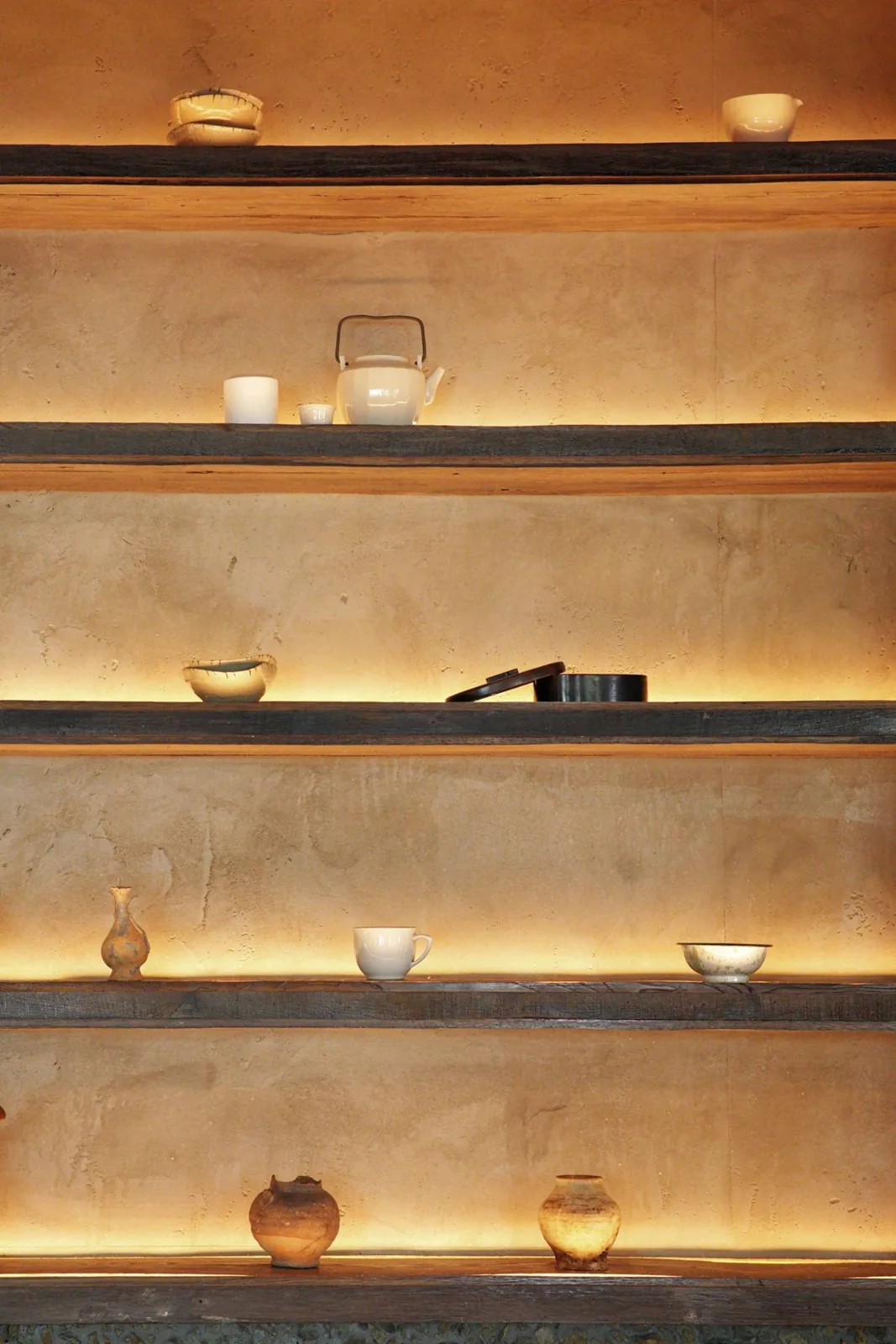 Prateleiras com vasos de barro iluminados