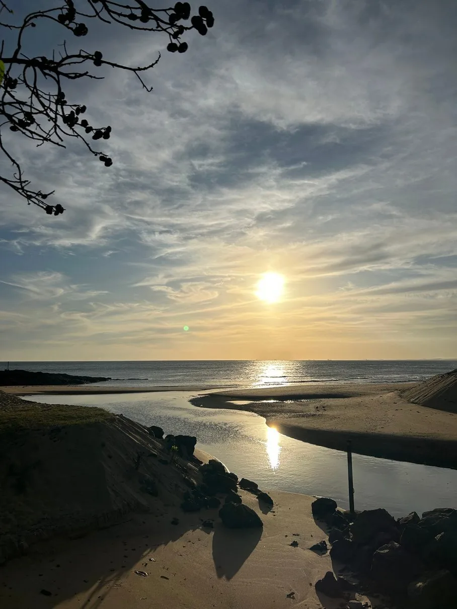 O encontro do rio com o mar ao entardecer